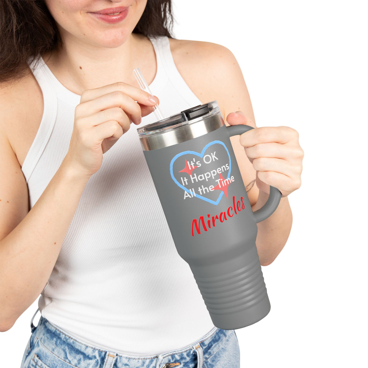 40oz faith-based travel mug with “Miracles Happen” design message "It's Ok, It Happens All the Time - Miracles," inspirational stainless steel tumbler, leak-proof lid, double-wall insulated, gray - girl holding mug