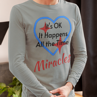 Long-sleeve Bella+Canvas t-shirt made from preshrunk ring-spun cotton with “Miracles Happen” design and message, “It’s OK. It Happens All the Time – Miracles,” faith-based apparel encouraging daily miracles through intimacy with God, man wearing long-sleeve gray t-shirt