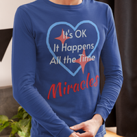 Long-sleeve Bella+Canvas t-shirt made from preshrunk ring-spun cotton with “Miracles Happen” design and message, “It’s OK. It Happens All the Time – Miracles,” faith-based apparel encouraging daily miracles through intimacy with God, man wearing long-sleeve blue t-shirt