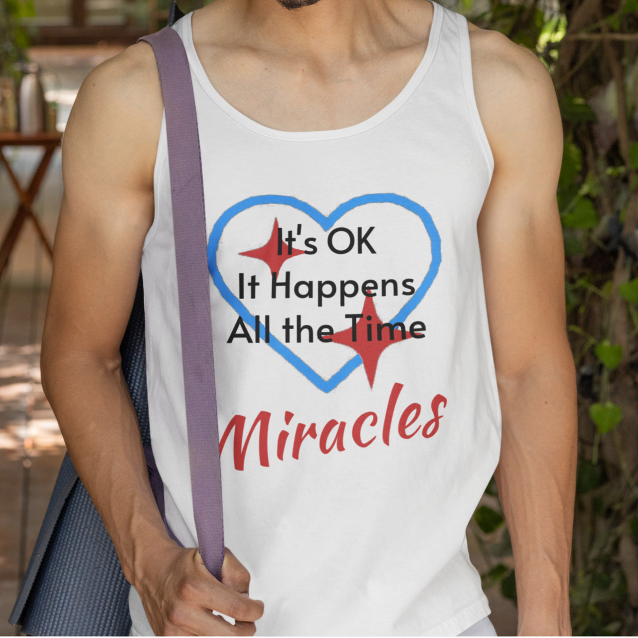 Lightweight Bella+Canvas tank top made from preshrunk cotton with “Miracles Happen” design message, “It’s OK. It Happens All the Time – Miracles,” inspirational apparel encouraging daily miracles through intimacy with God, man wearing white tank top