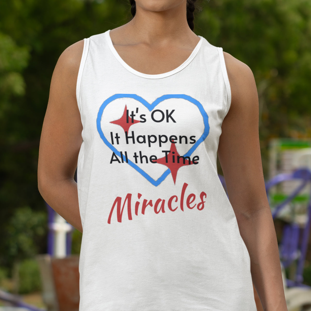 Lightweight Bella+Canvas tank top made from preshrunk cotton with “Miracles Happen” design message, “It’s OK. It Happens All the Time – Miracles,” inspirational apparel encouraging daily miracles through intimacy with God, woman wearing white tank top