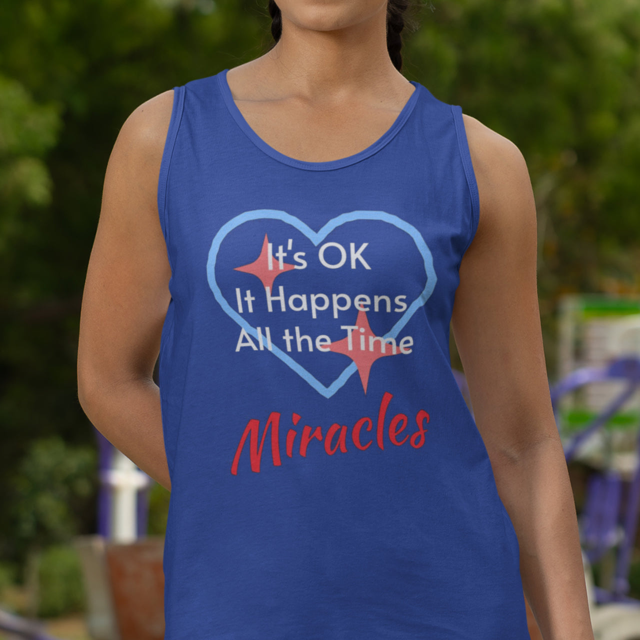 Lightweight Bella+Canvas tank top made from preshrunk cotton with “Miracles Happen” design message, “It’s OK. It Happens All the Time – Miracles,” inspirational apparel encouraging daily miracles through intimacy with God, woman wearing blue tank top