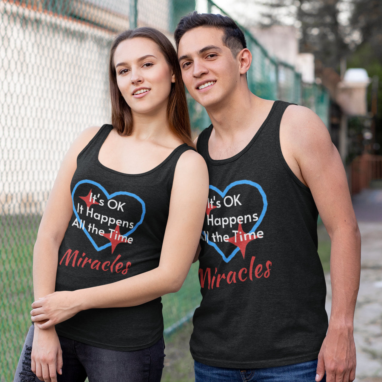 Lightweight Bella+Canvas tank top made from preshrunk cotton with “Miracles Happen” design message, “It’s OK. It Happens All the Time – Miracles,” inspirational apparel encouraging daily miracles through intimacy with God, couple wearing black tank top