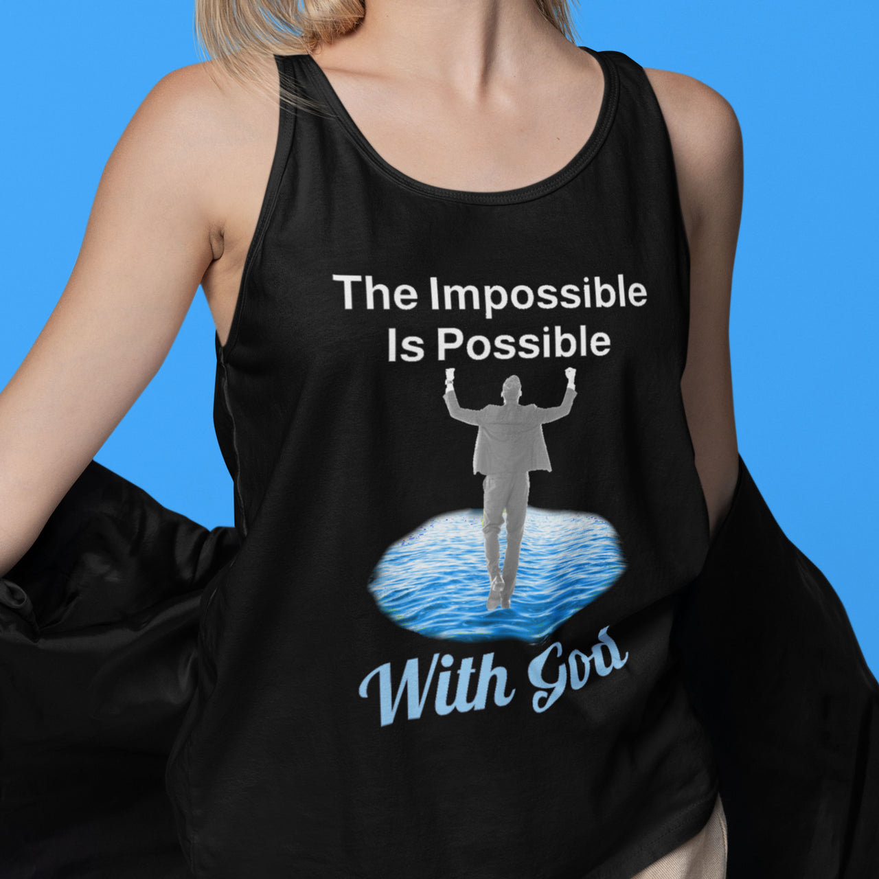 Lightweight Bella+Canvas tank top made from preshrunk cotton with “Impossible Man” design message, “The Impossible Is Possible with God,” inspirational apparel calling believers to step out in faith and walk with God into new possibilities, woman wearing black tank top