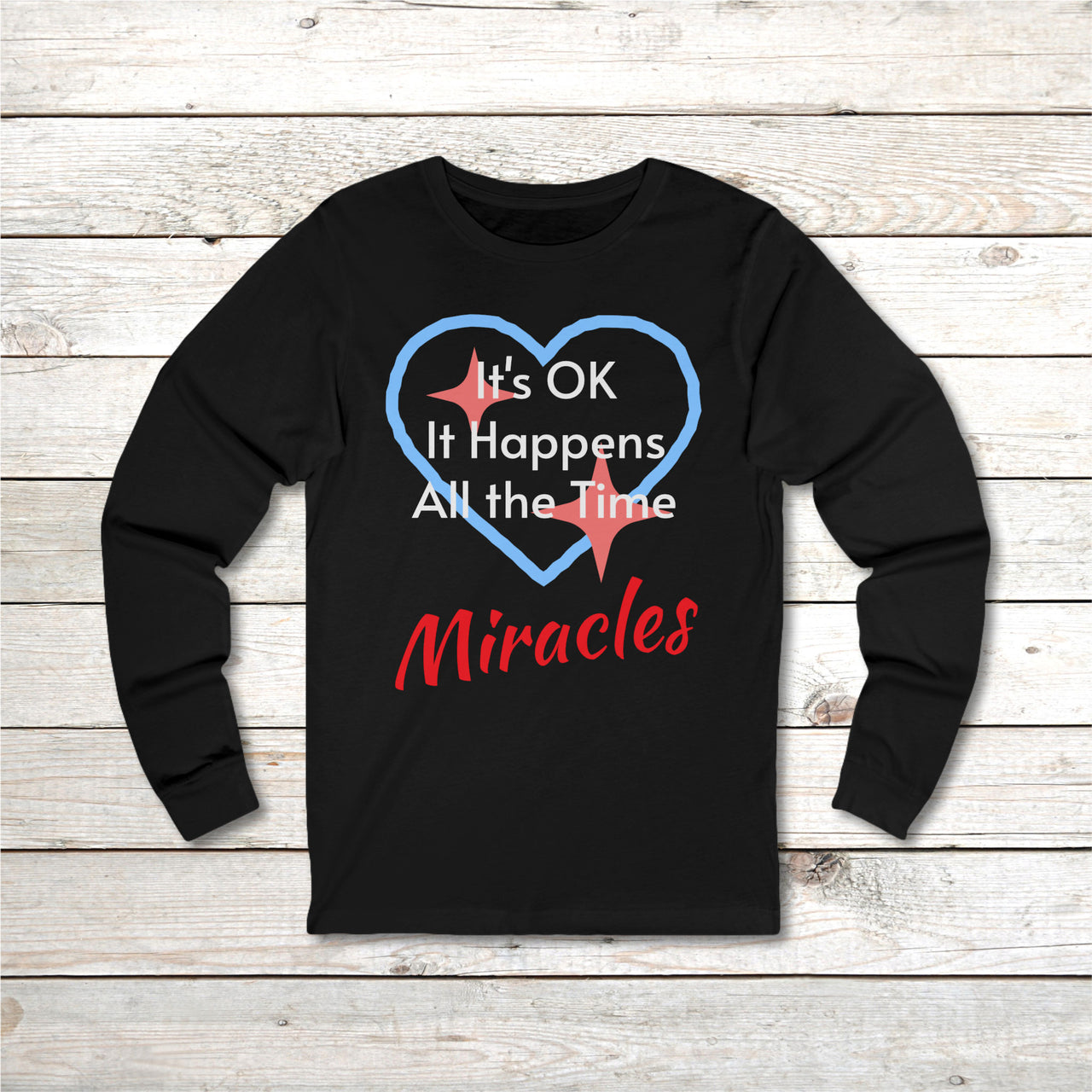 Long-sleeve Bella+Canvas t-shirt made from preshrunk ring-spun cotton with “Miracles Happen” design and message, “It’s OK. It Happens All the Time – Miracles,” faith-based apparel encouraging daily miracles through intimacy with God, front of long-sleeve black t-shirt