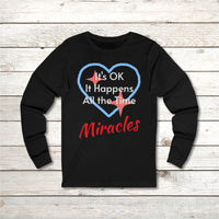 Long-sleeve Bella+Canvas t-shirt made from preshrunk ring-spun cotton with “Miracles Happen” design and message, “It’s OK. It Happens All the Time – Miracles,” faith-based apparel encouraging daily miracles through intimacy with God, front of long-sleeve black t-shirt