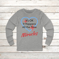 Long-sleeve Bella+Canvas t-shirt made from preshrunk ring-spun cotton with “Miracles Happen” design and message, “It’s OK. It Happens All the Time – Miracles,” faith-based apparel encouraging daily miracles through intimacy with God, front of gray long-sleeve t-shirt