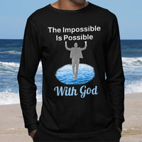 Long-sleeve Bella+Canvas t-shirt made from preshrunk ring-spun cotton with “Impossible Man” design message, “The Impossible Is Possible with God,” inspirational apparel calling believers to step out in faith and trust God for more than they can ask or imagine, man wearing black long-sleeve t-shirt