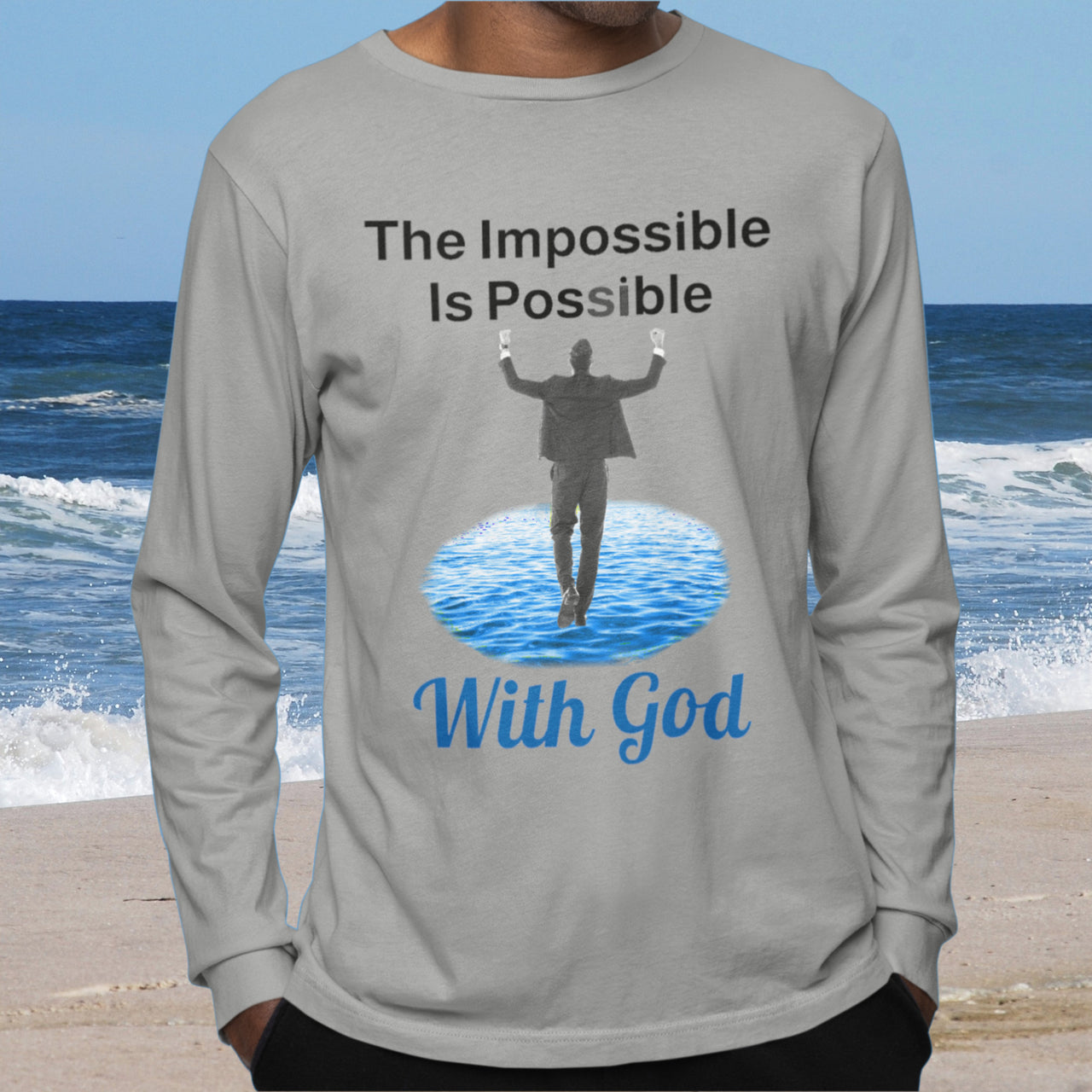 Long-sleeve Bella+Canvas t-shirt made from preshrunk ring-spun cotton with “Impossible Man” design message, “The Impossible Is Possible with God,” inspirational apparel calling believers to step out in faith and trust God for more than they can ask or imagine, man wearing gray long-sleeve t-shirt