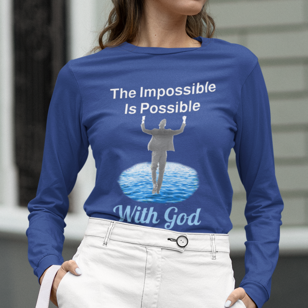 Long-sleeve Bella+Canvas t-shirt made from preshrunk ring-spun cotton with “Impossible Man” design message, “The Impossible Is Possible with God,” inspirational apparel calling believers to step out in faith and trust God for more than they can ask or imagine, woman wearing blue long-sleeve t-shirt