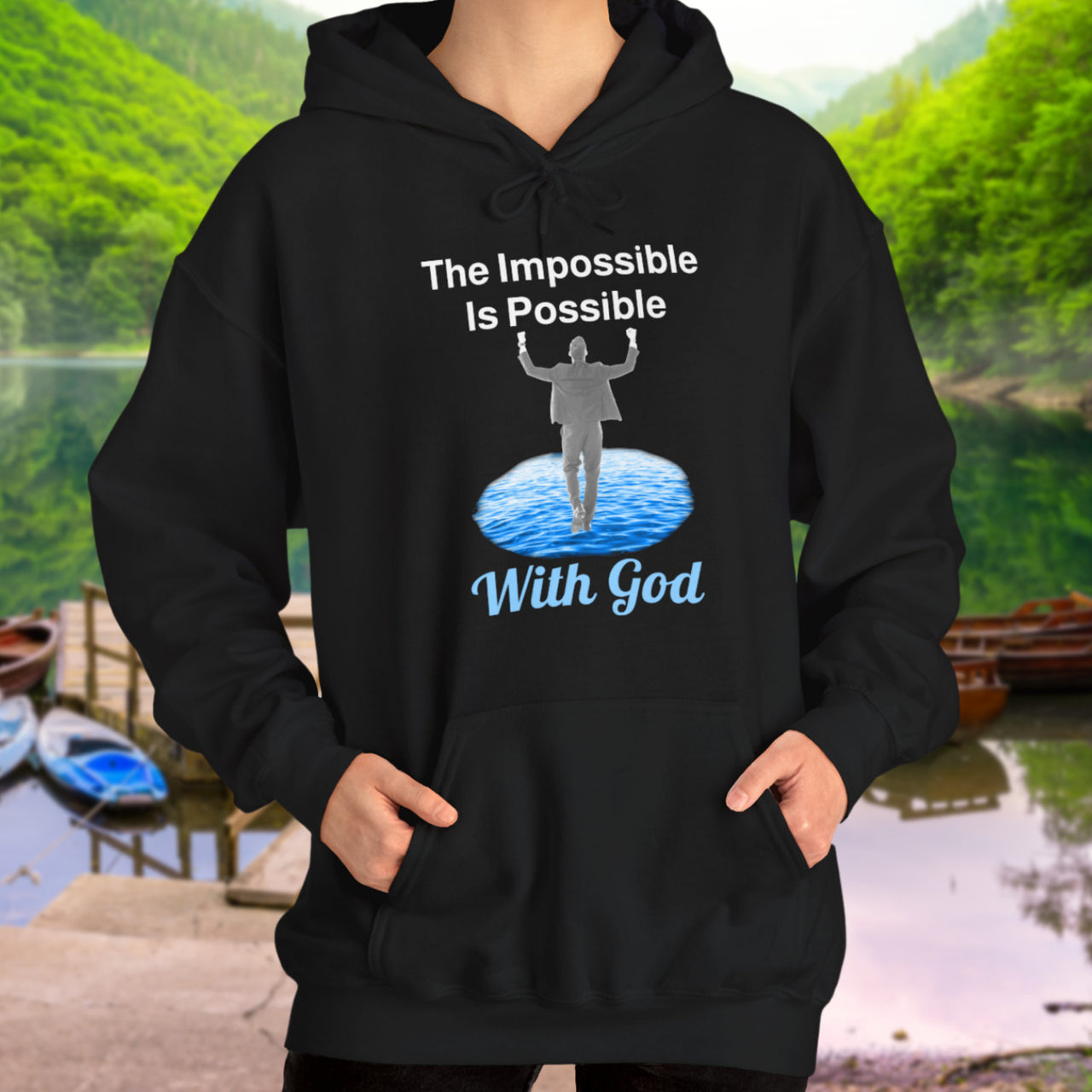 Gildan unisex hoodie with “Impossible Man” design featuring a man walking on water and uplifting message, Christian apparel made from soft cotton-poly blend, perfect for cold weather and spiritual encouragement, woman in black hoodie