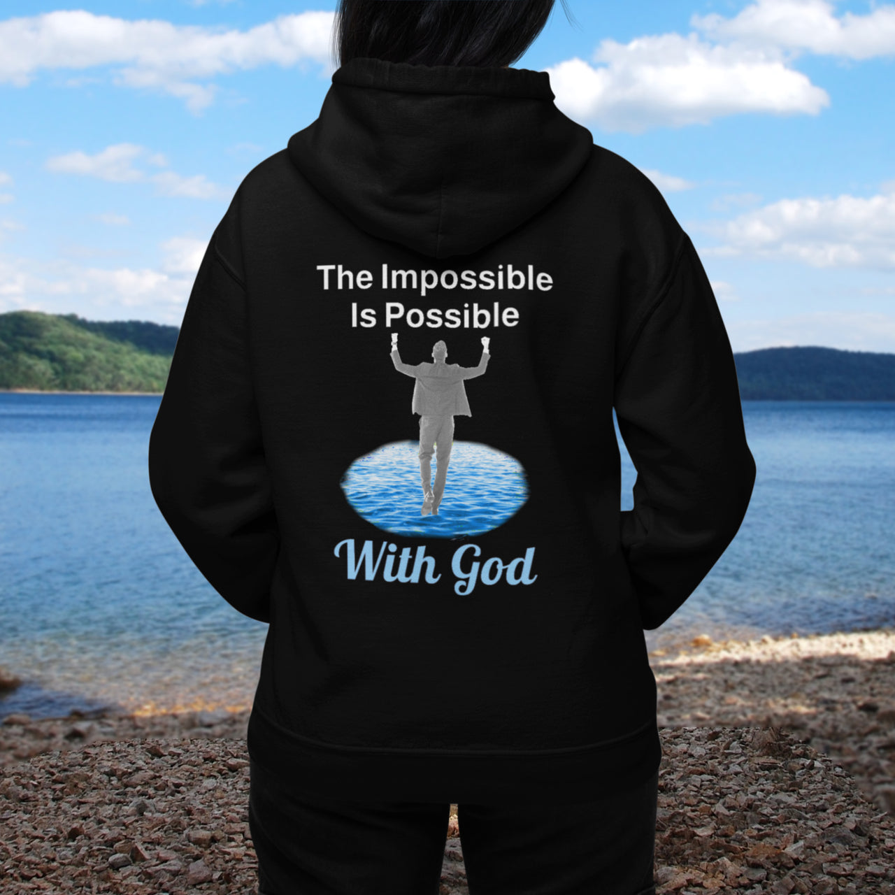 Gildan unisex zip-up hoodie with “Impossible Man” design featuring a man walking on water and uplifting message, Christian apparel made from soft cotton-poly fleece, perfect for cold weather and spiritual encouragement, woman in black hoodie