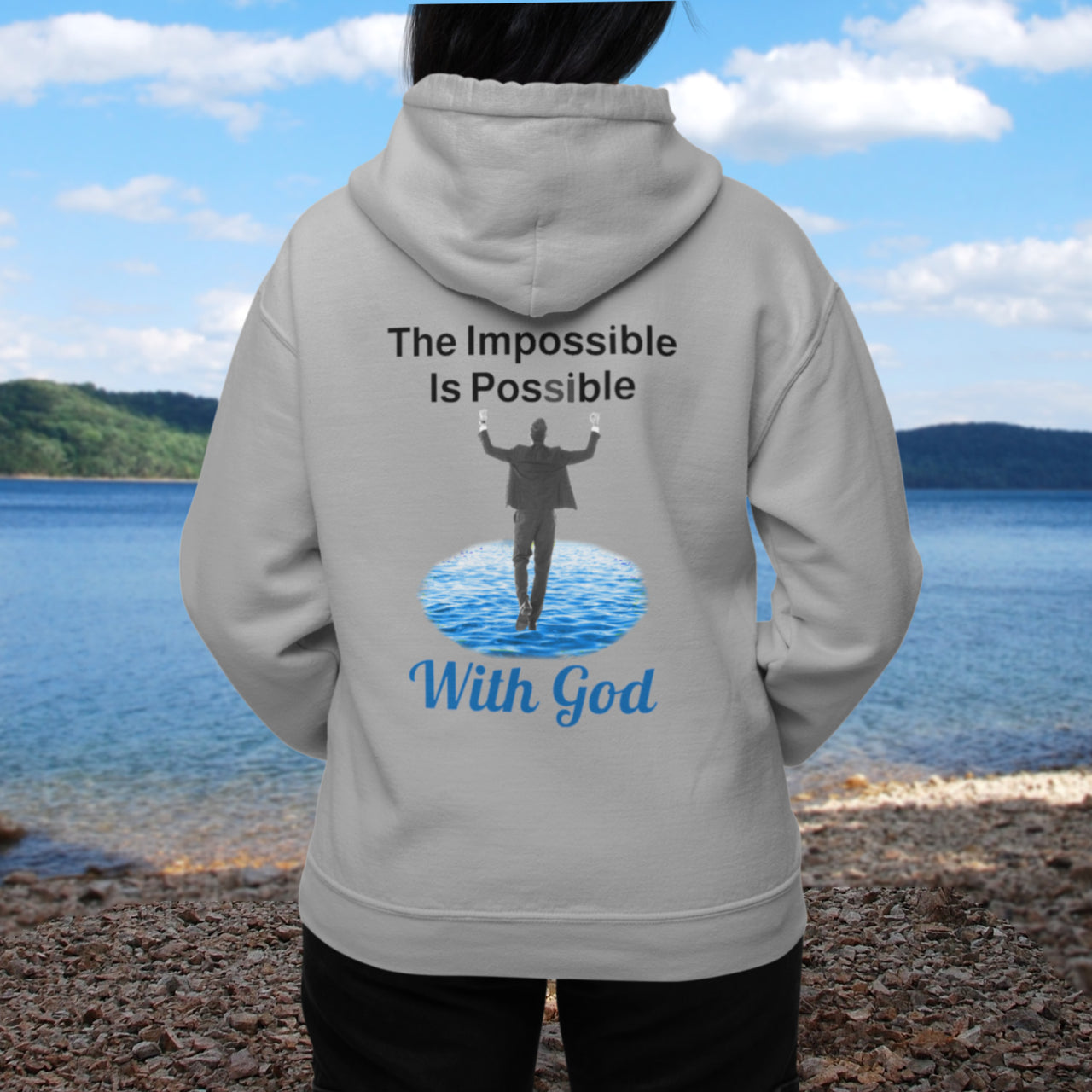 Gildan unisex zip-up hoodie with “Impossible Man” design featuring a man walking on water and uplifting message, Christian apparel made from soft cotton-poly fleece, perfect for cold weather and spiritual encouragement, woman in gray hoodie