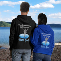 Gildan unisex zip-up hoodie with “Impossible Man” design featuring a man walking on water and uplifting message, Christian apparel made from soft cotton-poly fleece, perfect for cold weather and spiritual encouragement, couple in black and blue hoodie