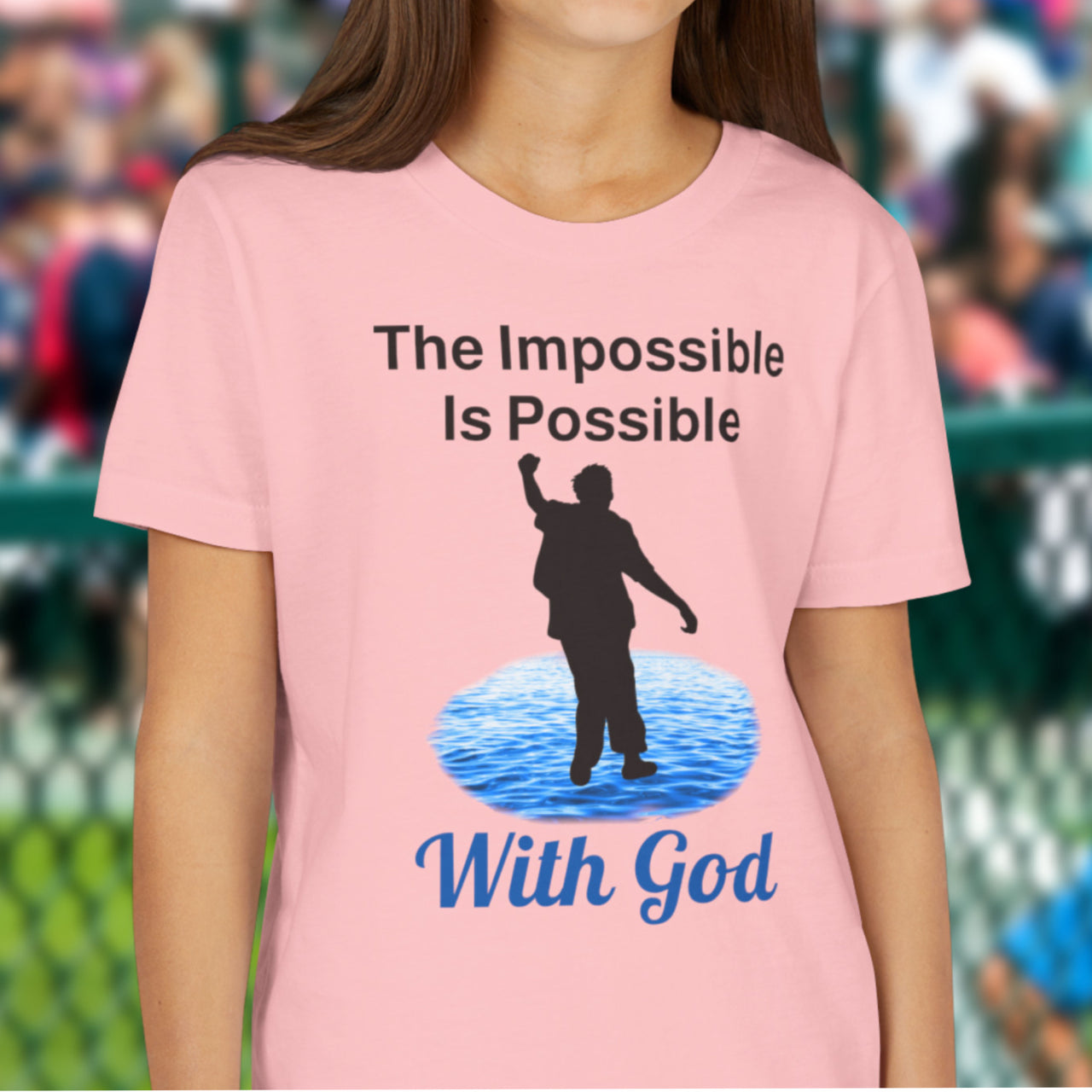 Bella+Canvas youth unisex t-shirt with “Impossible Teen” design featuring a teen walking on water and uplifting message, Christian apparel made from soft cotton, perfect for active wear and spiritual encouragement, girl in pink t-shirt