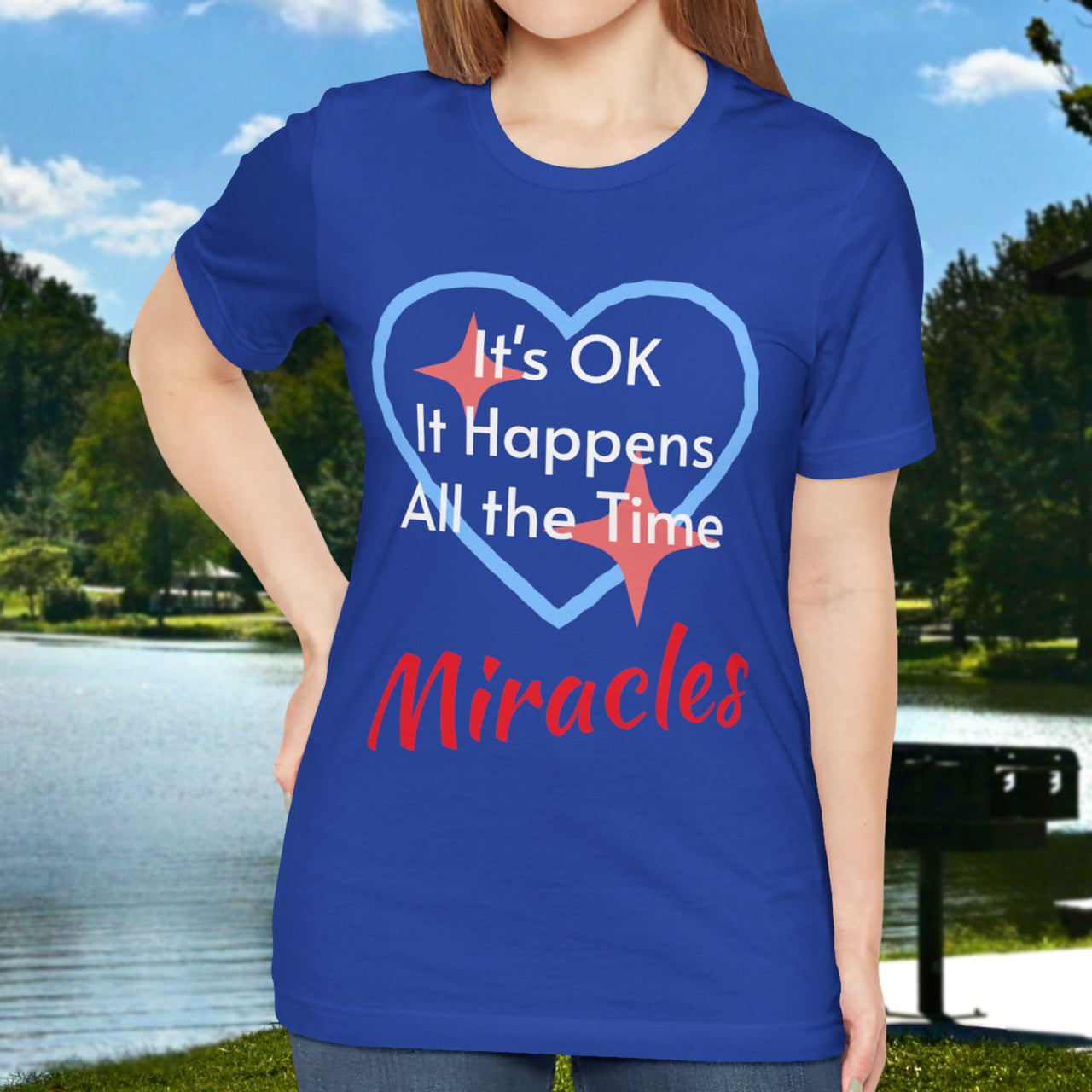 Soft, breathable Bella+Canvas t-shirt made from preshrunk cotton with “Miracles Happen” design message, “It’s OK. It Happens All the Time – Miracles,” inspirational shirt encouraging intimacy with God that produces everyday miracles, woman in blue shirt
