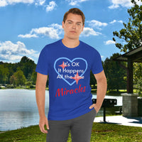 Soft, breathable Bella+Canvas t-shirt made from preshrunk cotton with “Miracles Happen” design message, “It’s OK. It Happens All the Time – Miracles,” inspirational shirt encouraging intimacy with God that produces everyday miracles, man in blue t-shirt at lakeside park