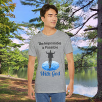 Soft, breathable Bella+Canvas t-shirt made from preshrunk cotton with “Impossible Man” design message, “The Impossible Is Possible with God,” inspirational shirt encouraging bold faith to step out and follow God into the impossible, man in gray t-shirt at park