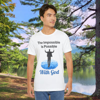 Soft, breathable Bella+Canvas t-shirt made from preshrunk cotton with “Impossible Man” design message, “The Impossible Is Possible With God,” inspirational shirt encouraging bold faith to step out and follow God into the impossible, man in white t-shirt at park