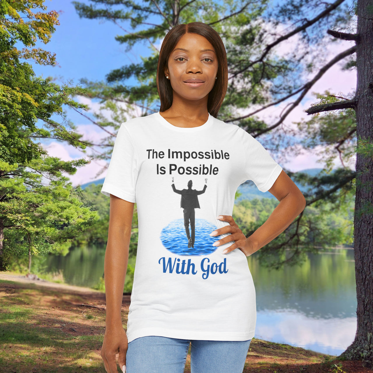 Soft, breathable Bella+Canvas t-shirt made from preshrunk cotton with “Impossible Man” design message, “The Impossible Is Possible with God,” inspirational shirt encouraging bold faith to step out and follow God into the impossible, woman in white t-shirt at park