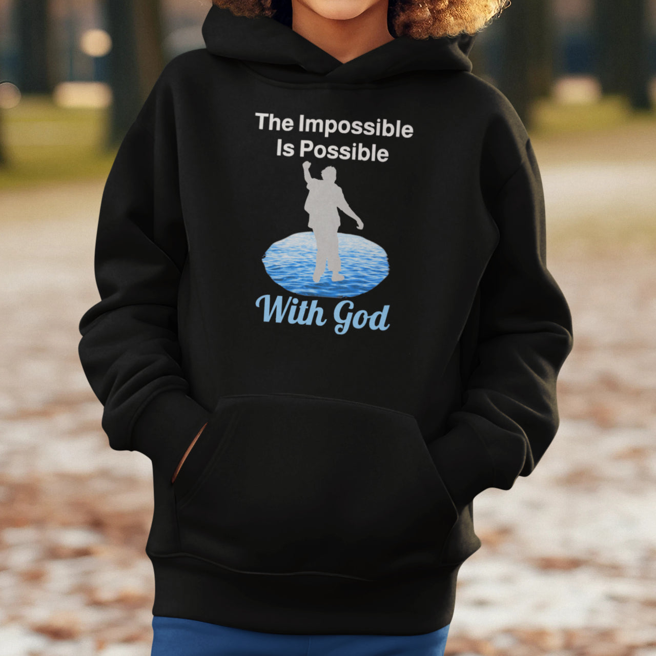 Gildan youth unisex hoodie with “Impossible Teen” design featuring a teen walking on water and uplifting message, Christian apparel made from soft preshrunk fleece, perfect for cold weather and spiritual encouragement, boy in black hoodie