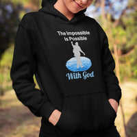 Gildan youth unisex hoodie with “Impossible Teen” design featuring a teen walking on water and uplifting message, Christian apparel made from soft preshrunk fleece, perfect for cold weather and spiritual encouragement, girl in black hoodie