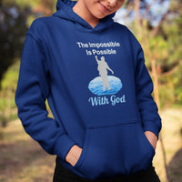 Gildan youth unisex hoodie with “Impossible Teen” design featuring a teen walking on water and uplifting message, Christian apparel made from soft preshrunk fleece, perfect for cold weather and spiritual encouragement, girl in blue hoodie