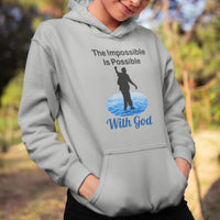 Gildan youth unisex hoodie with “Impossible Teen” design featuring a teen walking on water and uplifting message, Christian apparel made from soft preshrunk fleece, perfect for cold weather and spiritual encouragement, girl in gray hoodie