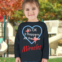 Rabbit Skins toddler long-sleeve t-shirt with “Miracles Happen” design and uplifting message, soft cotton, breathable and durable, Christian apparel for everyday wear and faith-filled gifting, todder girl in black long-sleeve t-shirt