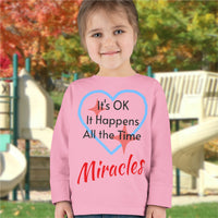 Rabbit Skins toddler long-sleeve t-shirt with “Miracles Happen” design and uplifting message, soft cotton, breathable and durable, Christian apparel for everyday wear and faith-filled gifting, todder girl in pink long-sleeve t-shirt