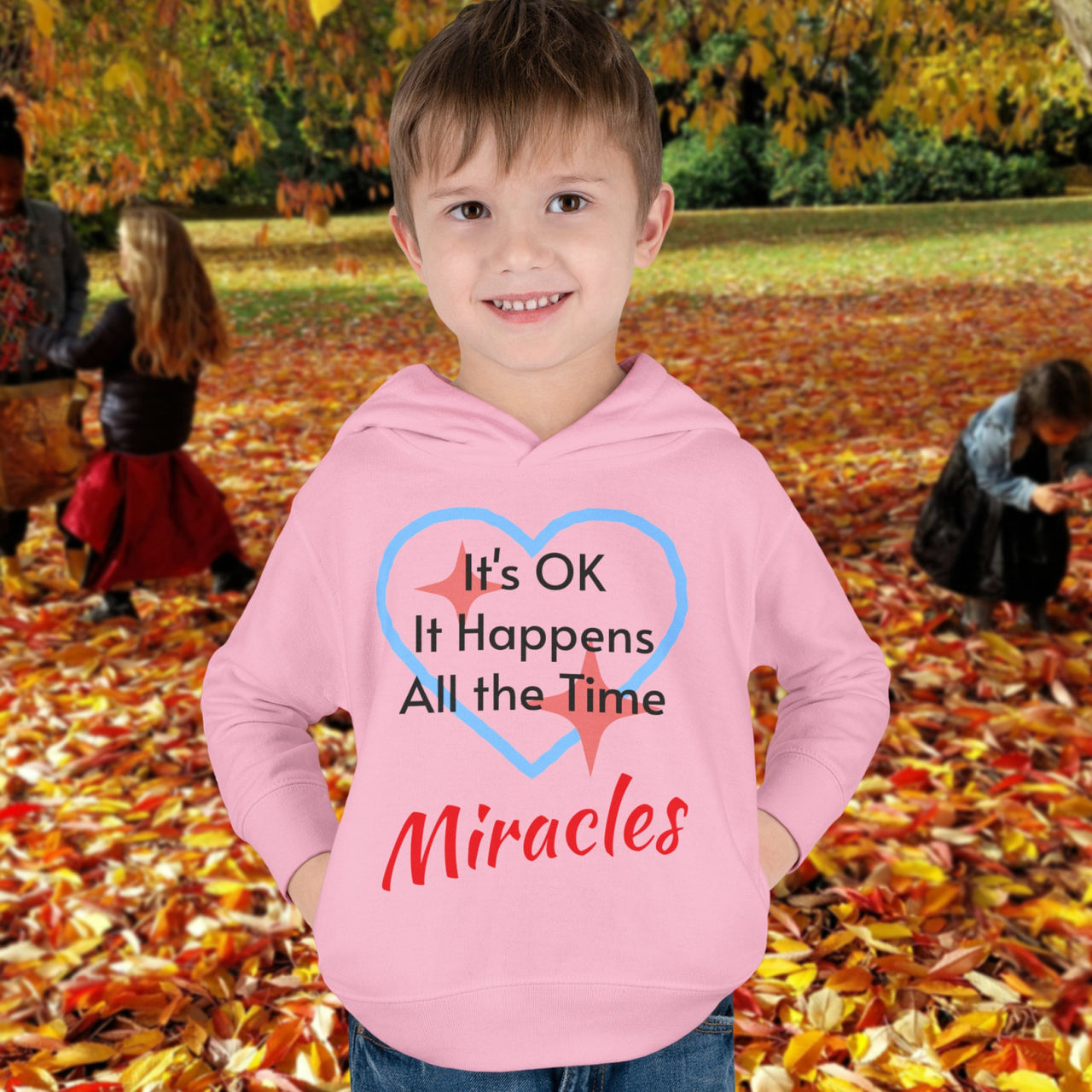 Rabbit Skins toddler fleece hoodie with “Miracles Happen” design and uplifting message, soft cotton-poly blend, jersey-lined hood, Christian apparel for cozy wear and faith-filled gifting, toddler boy in pink hoodie