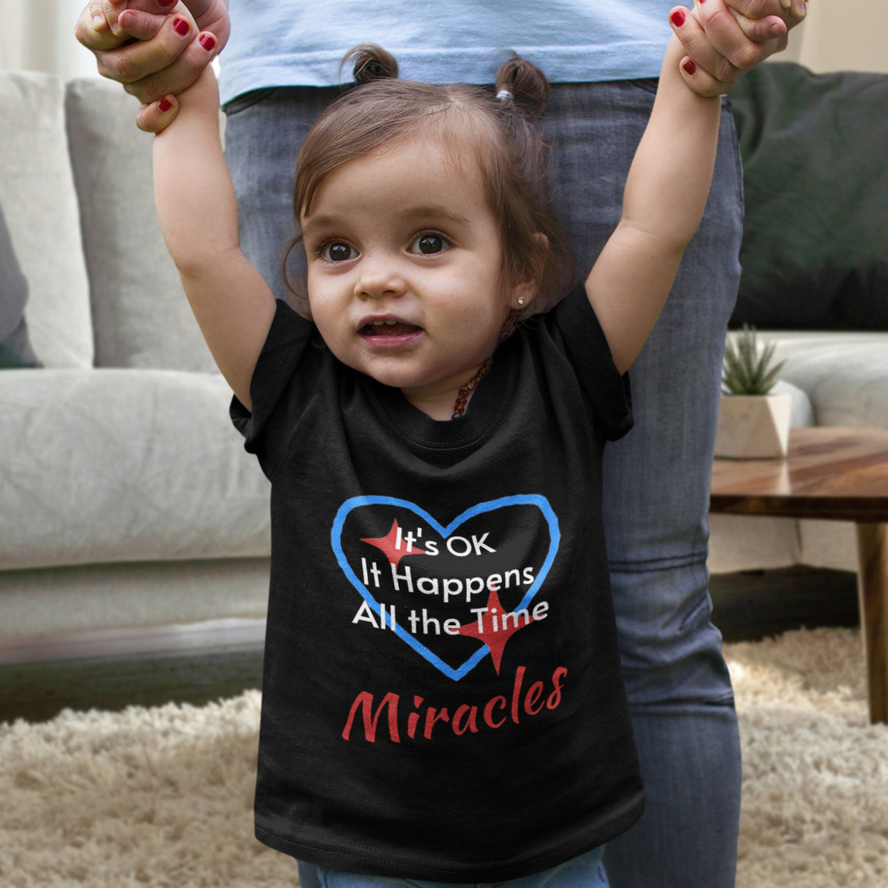 Bella+Canvas baby t-shirt with “Miracles Happen” design and uplifting message, soft cotton, breathable and durable, Christian apparel for infants and family matching, baby girl in black shirt