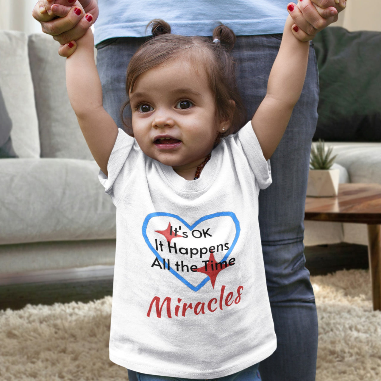 Bella+Canvas baby t-shirt with “Miracles Happen” design and uplifting message, soft cotton, breathable and durable, Christian apparel for infants and family matching, baby girl in white shirt