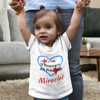 Bella+Canvas baby t-shirt with “Miracles Happen” design and uplifting message, soft cotton, breathable and durable, Christian apparel for infants and family matching, baby girl in white shirt