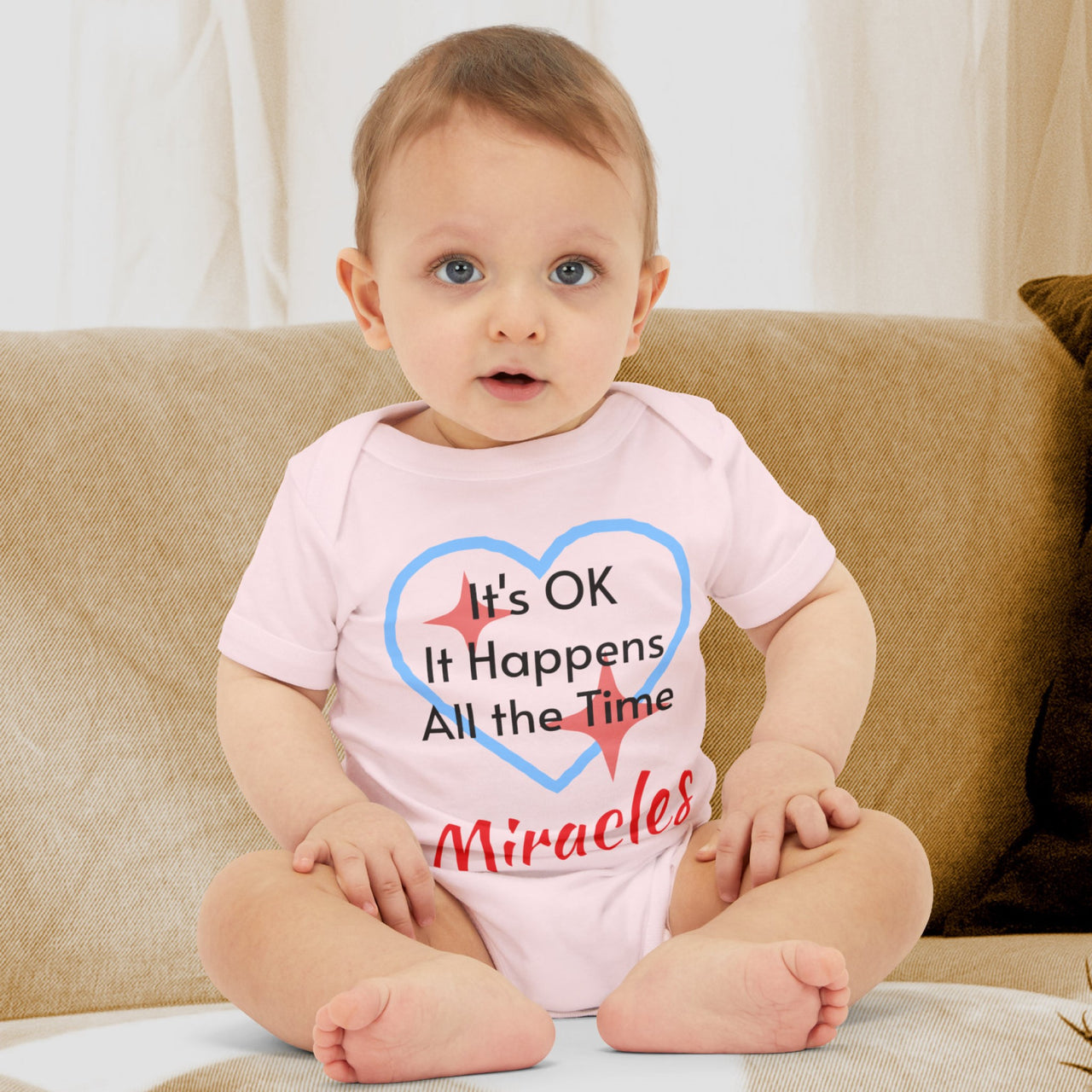 Bella+Canvas baby onesie with “Miracles Happen” design and uplifting message, soft cotton, envelope neck and snap closure, Christian apparel for infants and family matching, baby boy in pink onesie