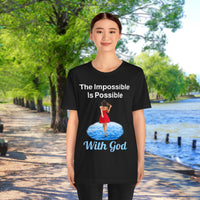 Soft, breathable Bella+Canvas t-shirt made from preshrunk cotton with “Impossible Woman” design message, “The Impossible Is Possible with God,” inspirational shirt encouraging bold obedience and faith-filled movement with God, Asian woman in black t-shirt at waterside walkway