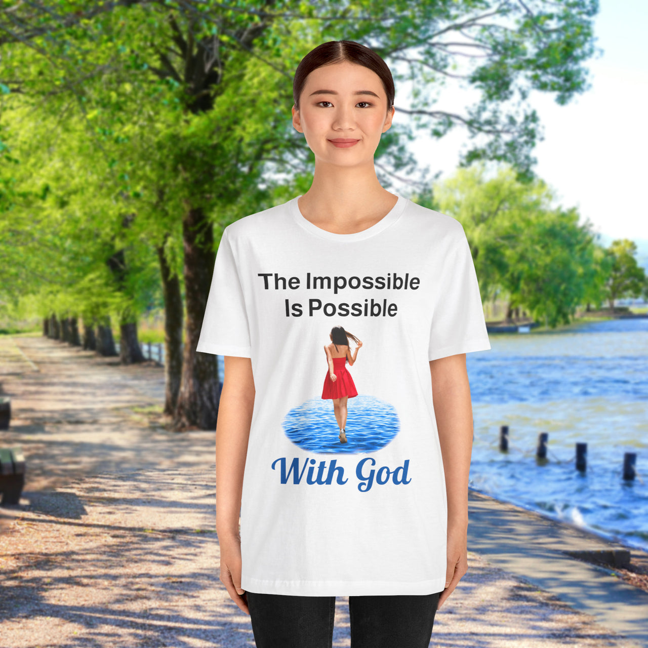 Soft, breathable Bella+Canvas t-shirt made from preshrunk cotton with “Impossible Woman” design message, “The Impossible Is Possible with God,” inspirational shirt encouraging bold obedience and faith-filled movement with God, 2nd woman in white t-shirt on waterside walkway