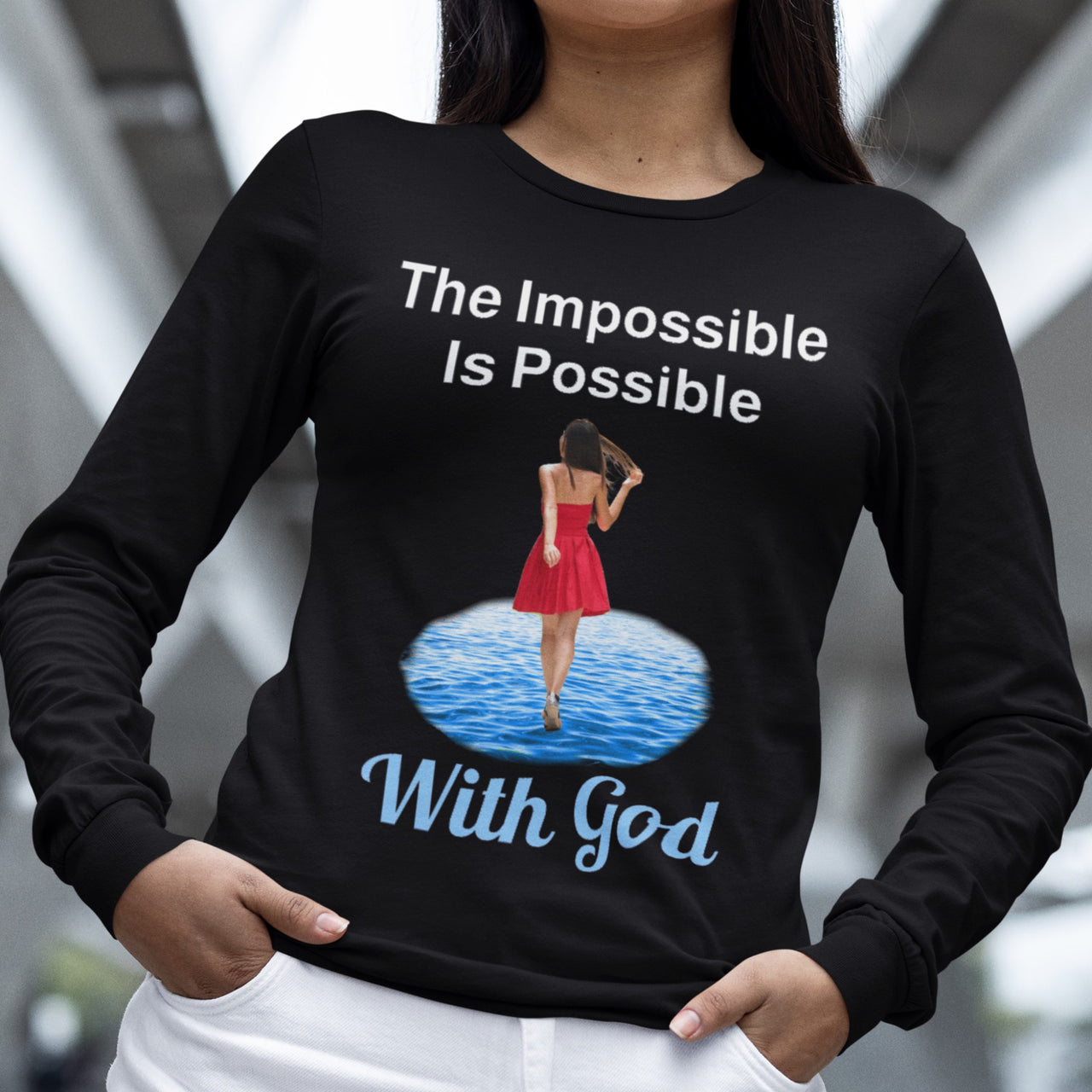 Long-sleeve Bella+Canvas t-shirt made from preshrunk ring-spun cotton with “Impossible Woman” design message, “The Impossible Is Possible with God,” inspirational apparel encouraging women to walk freely in God's incredible ways, woman wearing black long-sleeve t-shirt