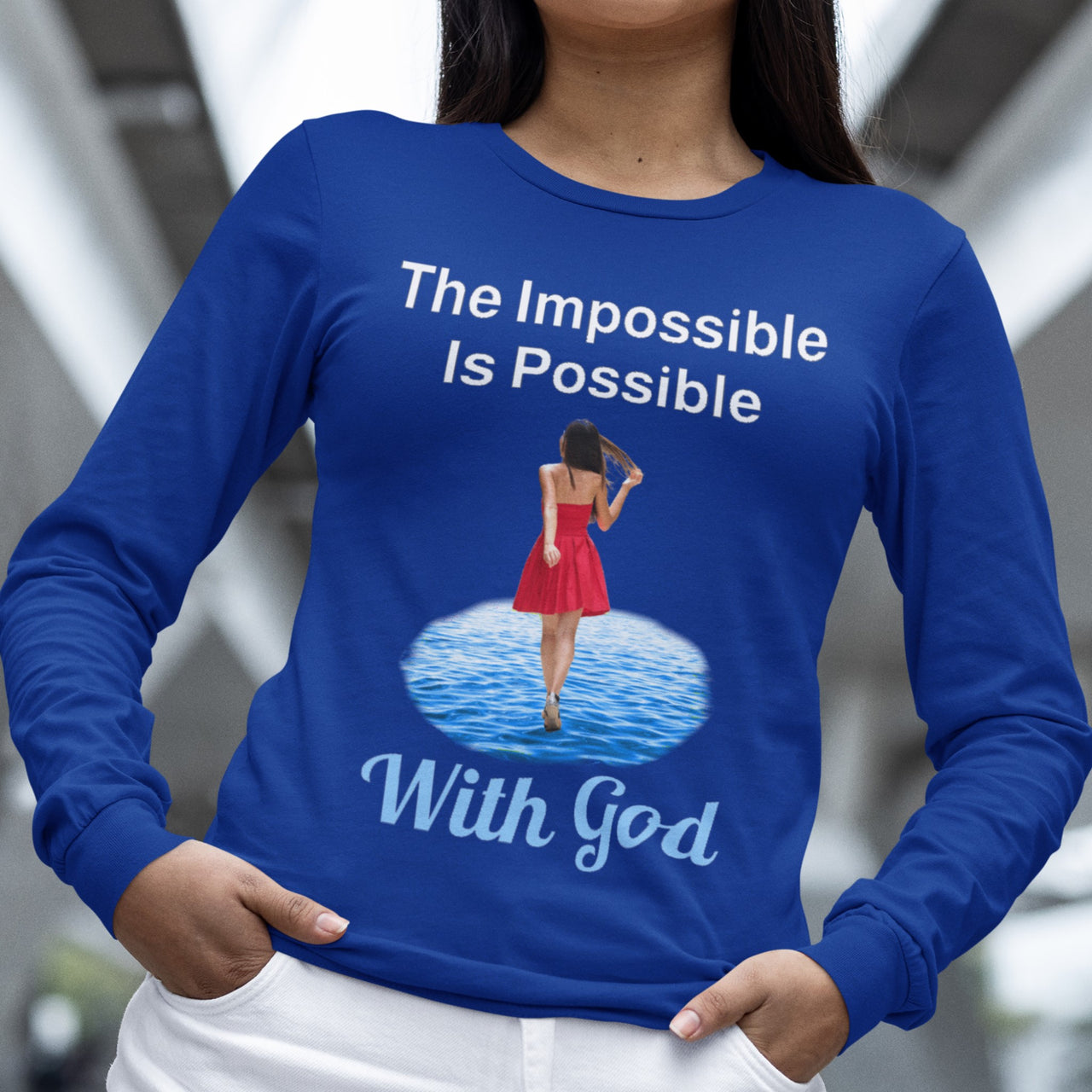 Long-sleeve Bella+Canvas t-shirt made from preshrunk ring-spun cotton with “Impossible Woman” design message, “The Impossible Is Possible with God,” inspirational apparel encouraging women to walk freely in God's incredible ways, woman wearing blue long-sleeve t-shirt
