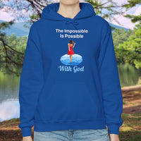 Gildan unisex hoodie with “Impossible Woman” design featuring a woman walking on water and uplifting message, Christian apparel made from soft cotton-poly blend, ideal for cold weather and faith-forward style, woman in blue hoodie