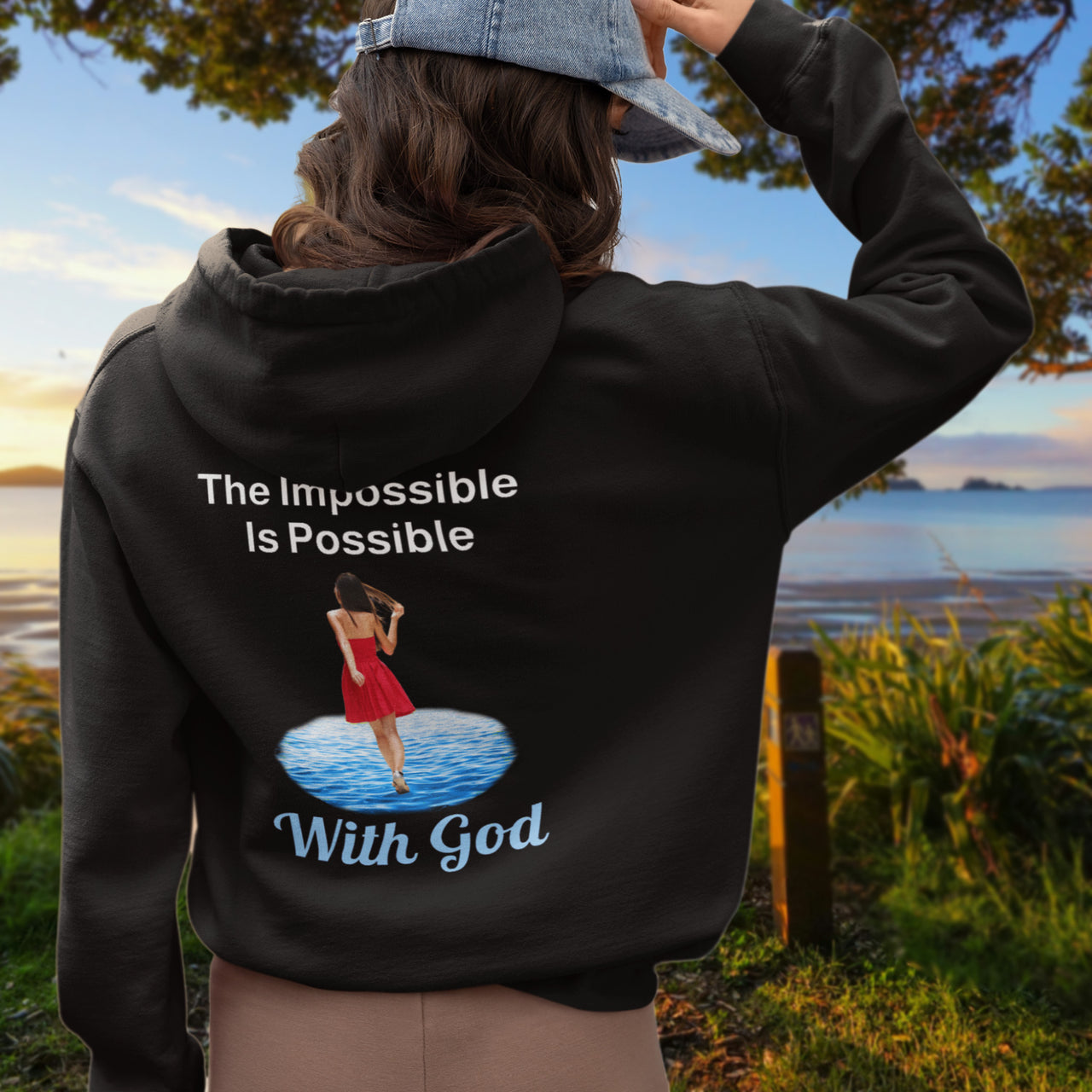 Gildan unisex zip-up hoodie with “Impossible Woman” design featuring a woman walking on water and uplifting message, Christian apparel made from soft cotton-poly fleece, ideal for cooler weather and faith-forward style, 2nd woman in black hoodie