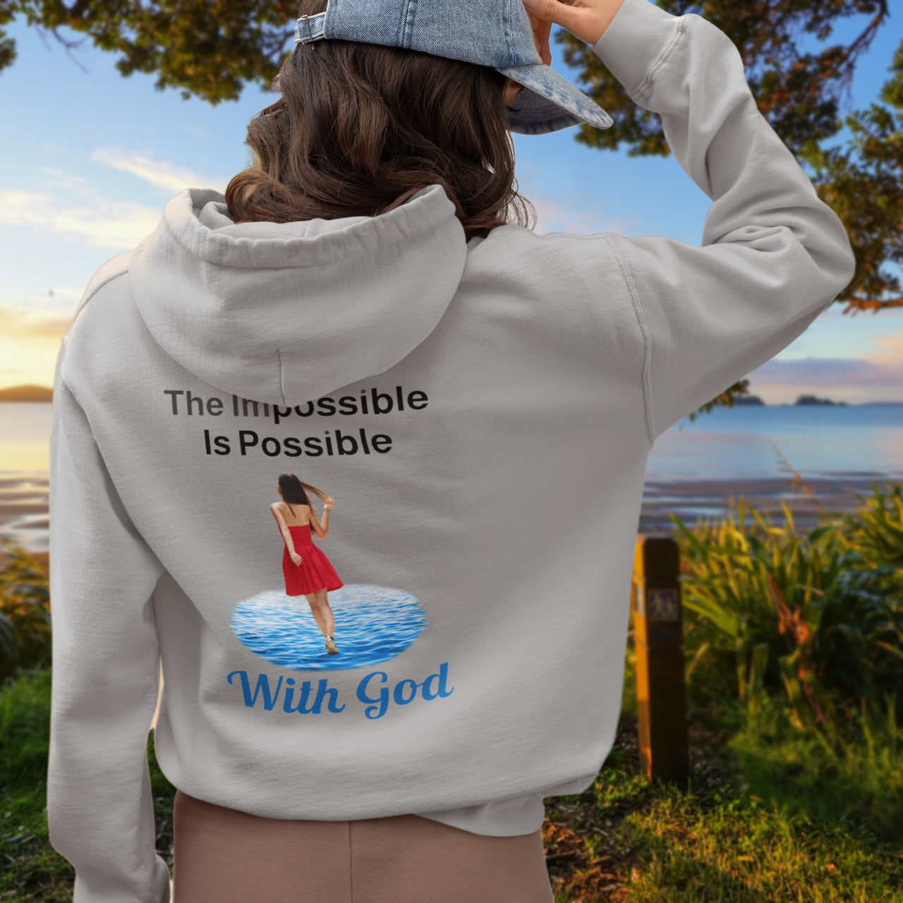 Gildan unisex zip-up hoodie with “Impossible Woman” design featuring a woman walking on water and uplifting message, Christian apparel made from soft cotton-poly fleece, ideal for cooler weather and faith-forward style, 2nd woman in gray hoodie