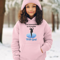 Gildan youth unisex hoodie with “Impossible Girl” design featuring a girl walking on water and uplifting message, Christian apparel made from soft preshrunk fleece, ideal for cooler weather and faith-forward style, girl in pink hoodie