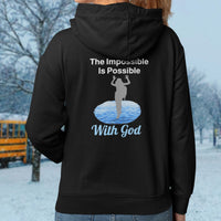 Gildan youth zip-up hoodie with “Impossible Girl” design featuring a girl walking on water and uplifting message, Christian apparel made from soft preshrunk fleece, ideal for cooler weather and faith-forward style, girl in black hoodie
