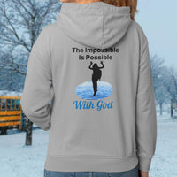 Gildan youth zip-up hoodie with “Impossible Girl” design featuring a girl walking on water and uplifting message, Christian apparel made from soft preshrunk fleece, ideal for cooler weather and faith-forward style, girl in gray hoodie