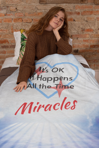 Inspirational plush blanket with “Miracles Happen” design and message