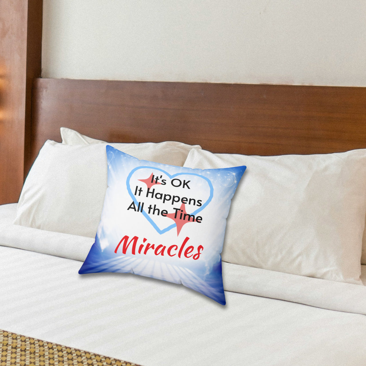 Inspirational throw pillow with “Miracles Happen” design with message "It's OK, It Happens All the Time - Miracle," reversible design, faith-based home décor, white or blue back, spun polyester, 4 sizes, 14x14 size on bed