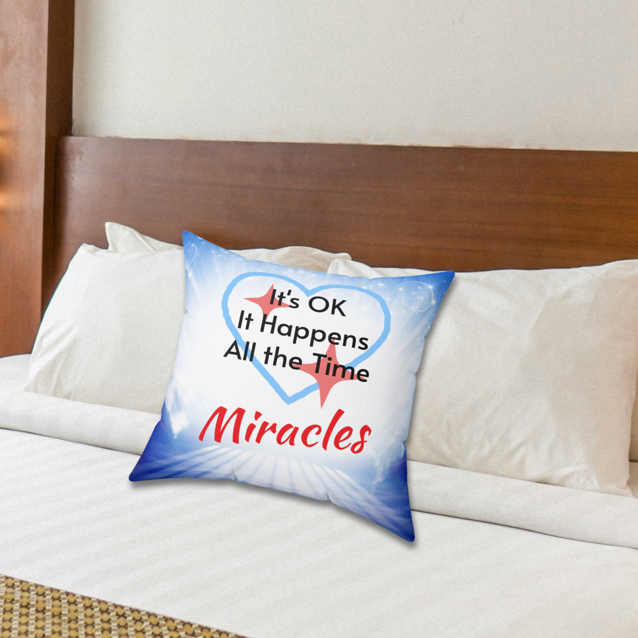 Inspirational throw pillow with “Miracles Happen” design with message "It's OK, It Happens All the Time - Miracle," reversible design, faith-based home décor, white or blue back, spun polyester, 4 sizes, 16x16 on bed