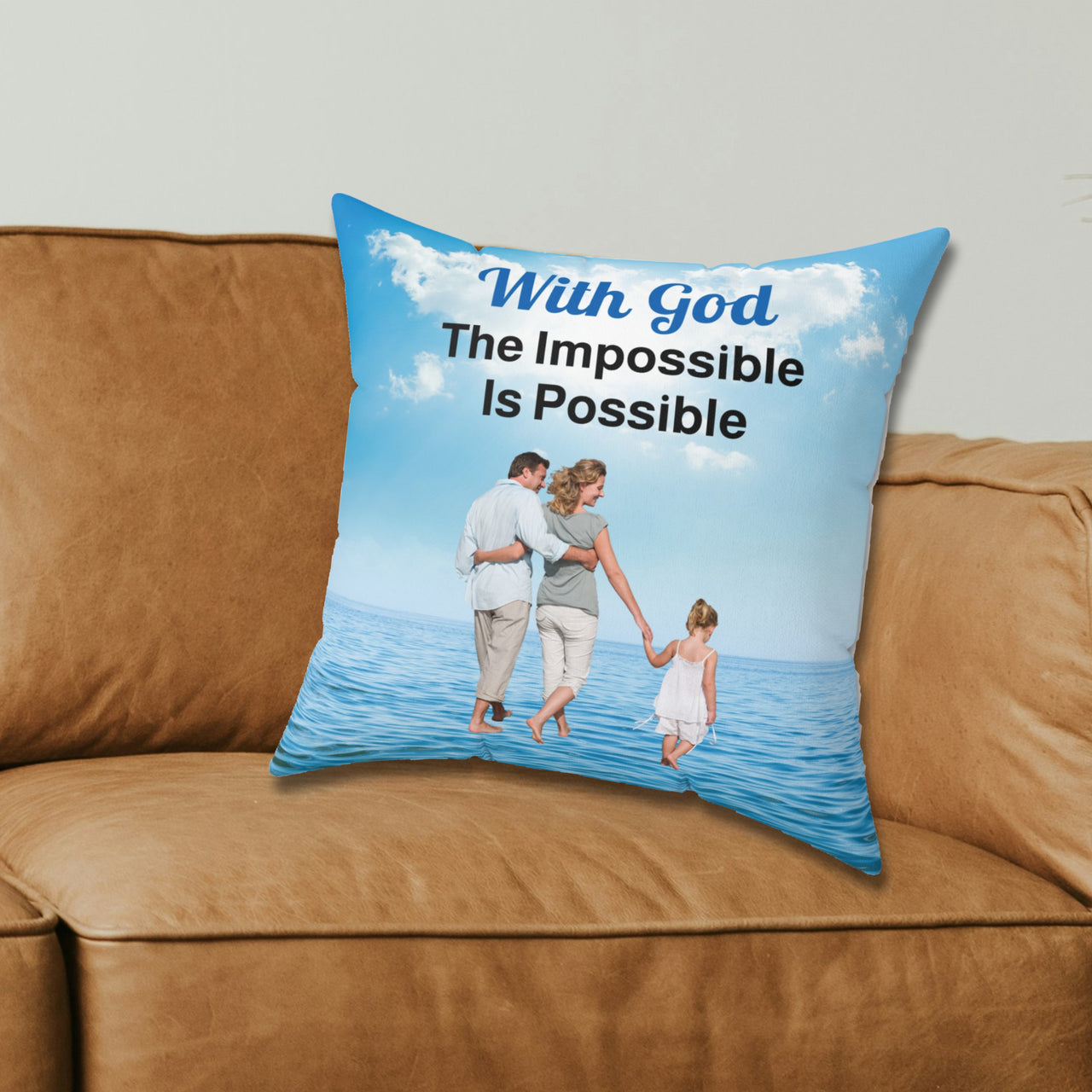Faith-based throw pillow with “Impossible Family” design, family walking on water with message "With God, The Impossible Is Possible," inspirational home décor, reversible with white or sea blue back, spun polyester, 4 sizes, 16x16 on couch