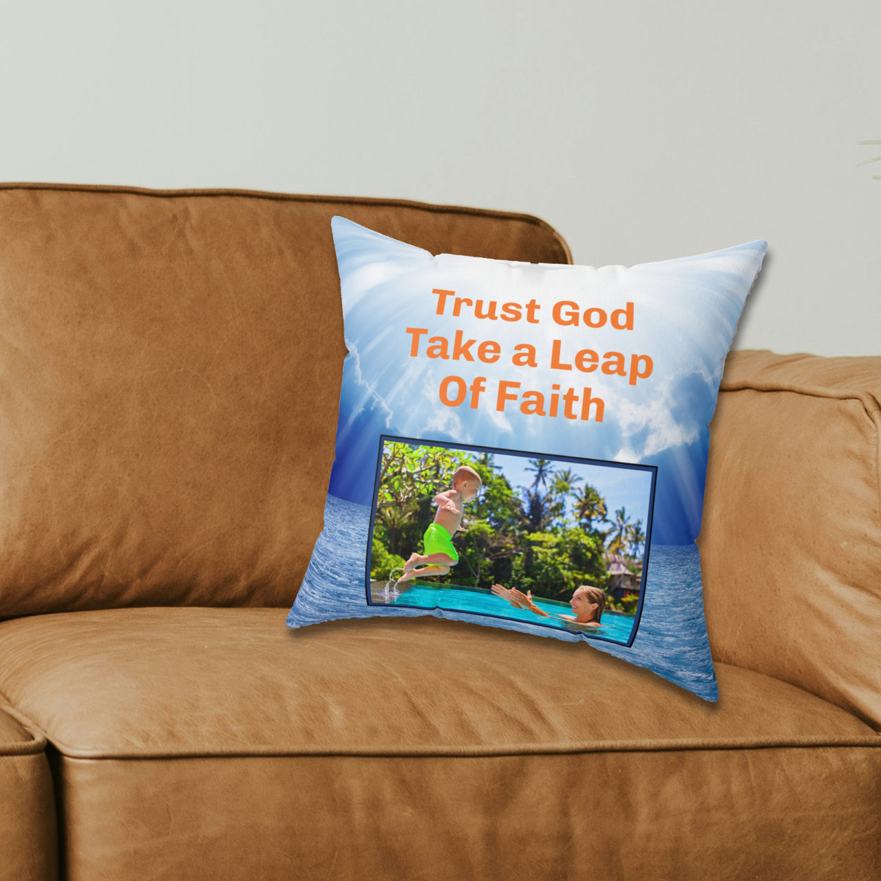Inspirational throw pillow with “Leap of Faith” design, child jumping into pool, faith-based message "Trust God, Take a Leap of Faith," faith-based home décor, reversible with white or blue back, spun polyester, 4 sizes, 14x14 on couch